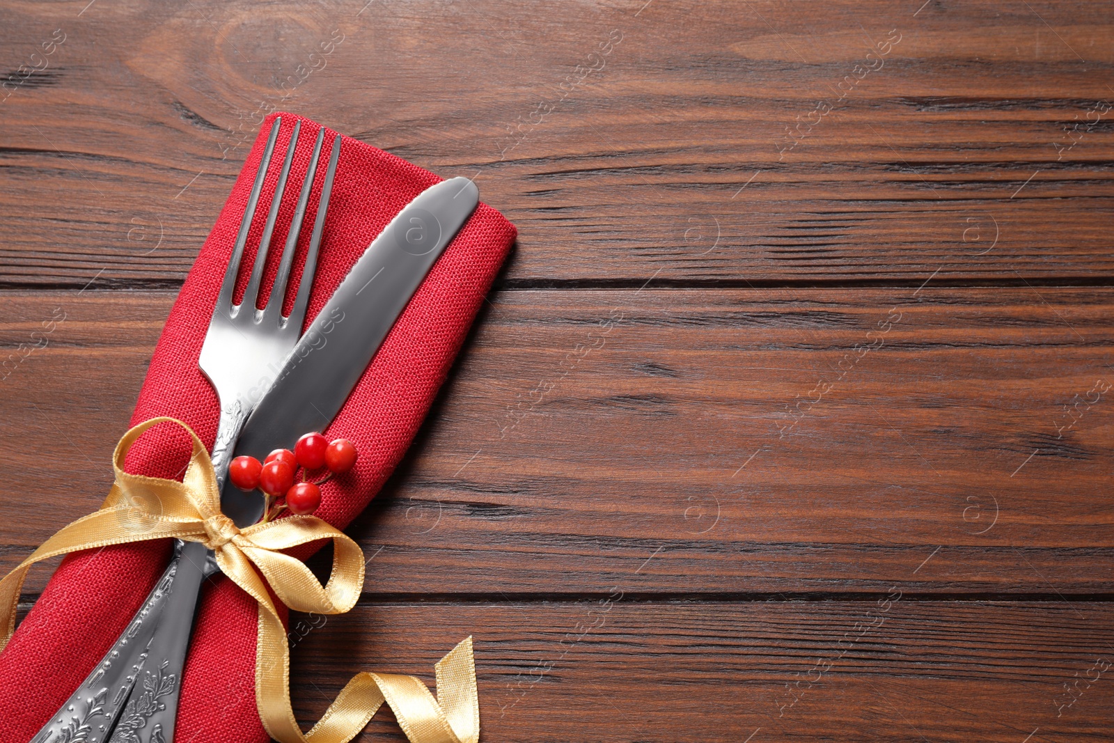 Photo of Cutlery set on wooden table, top view with space for text. Christmas celebration