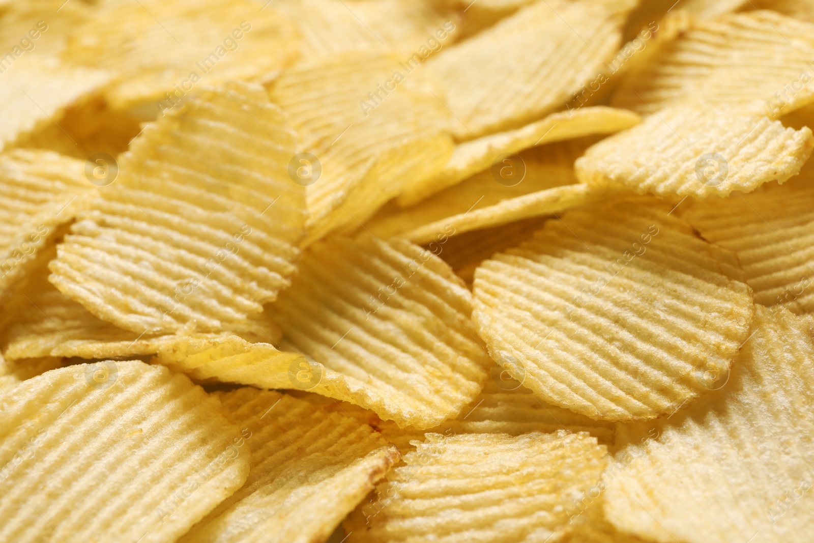 Photo of Pile of crispy potato chips as background, closeup