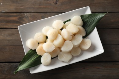 Photo of Fresh raw scallops on wooden table, top view