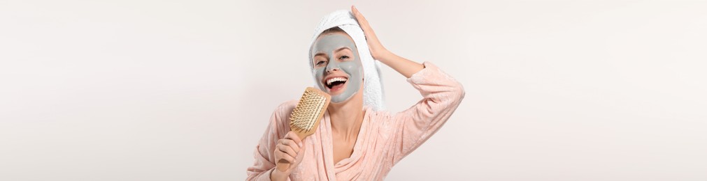 Spa treatment. Happy woman with face mask and brush singing on white background, banner design