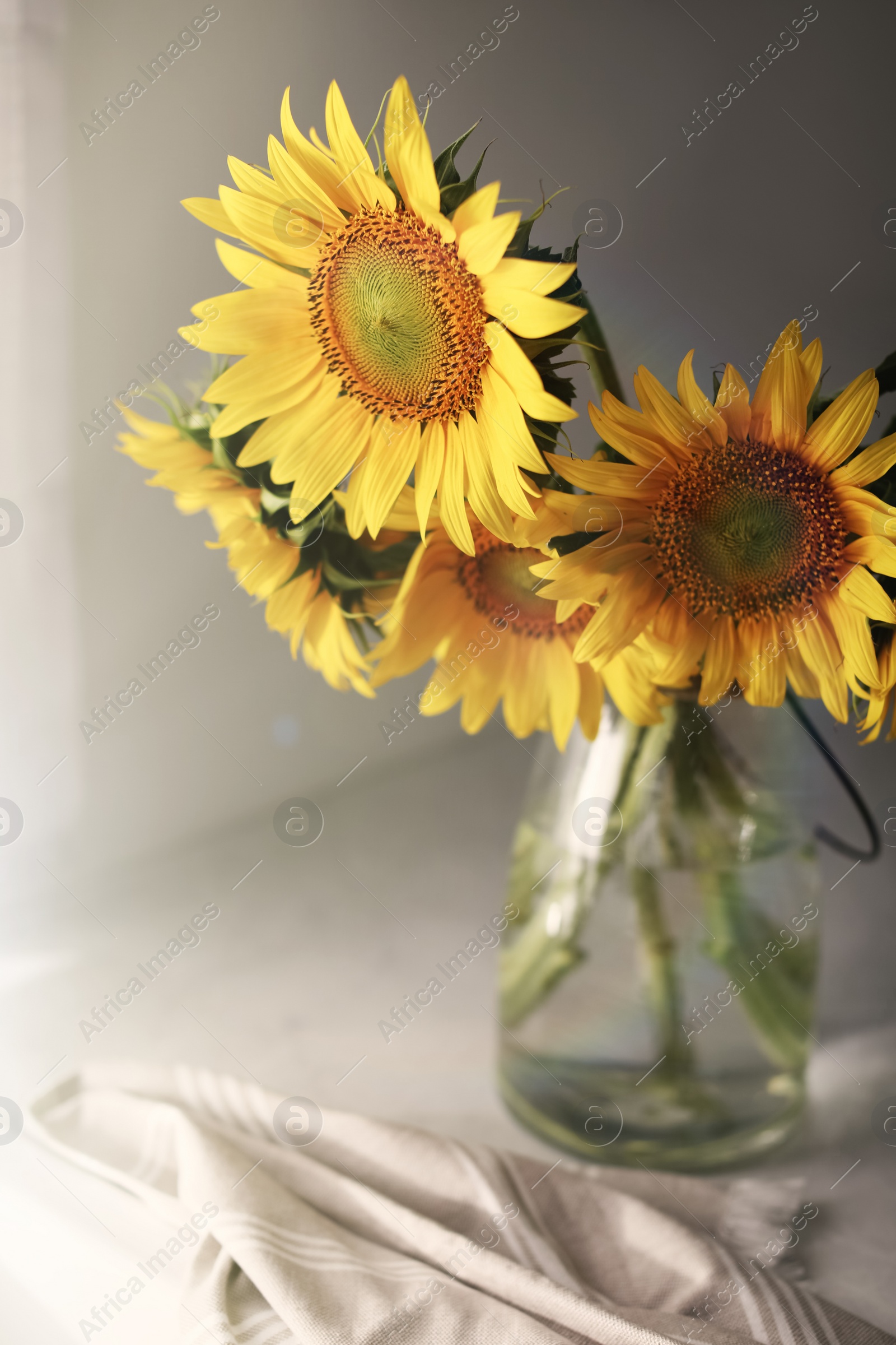 Photo of Vase with beautiful yellow sunflowers on table