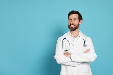 Photo of Happy doctor with stethoscope on light blue background. Space for text