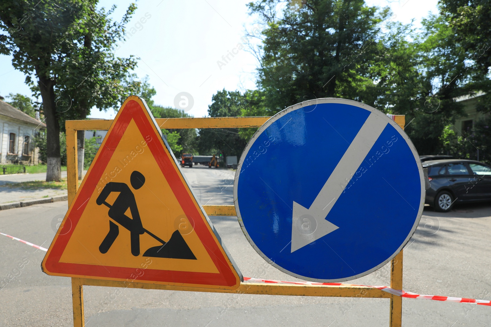 Photo of Barricade with traffic signs on city street. Road repair