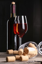 Photo of Red wine and corks on wooden table
