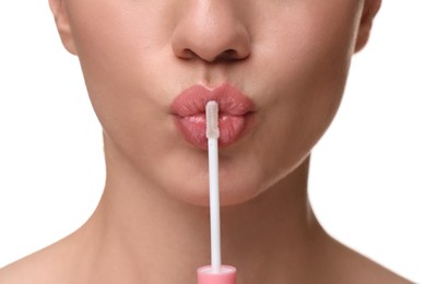 Woman with beautiful lip gloss and applicator on white background, closeup