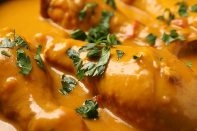 Photo of Tasty chicken curry with parsley as background, closeup