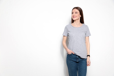 Young woman in t-shirt on light background. Mock up for design