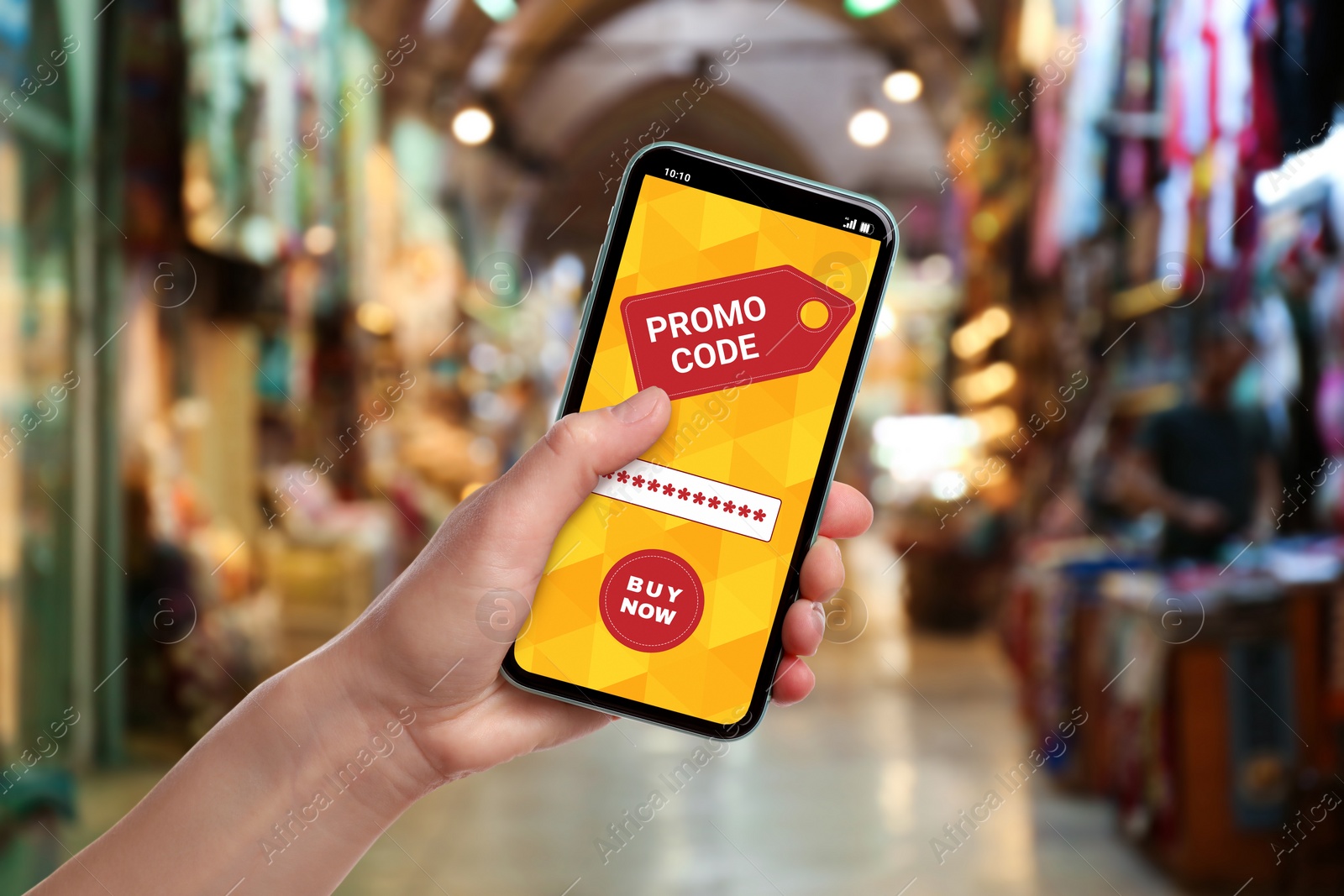 Image of Woman holding smartphone with activated promo code in shopping mall, closeup