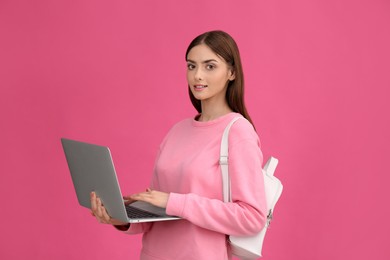 Photo of Teenage student with laptop and backpack on pink background