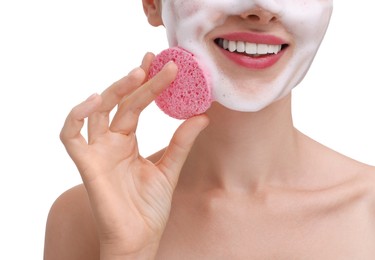 Photo of Happy young woman washing her face with sponge on white background, closeup