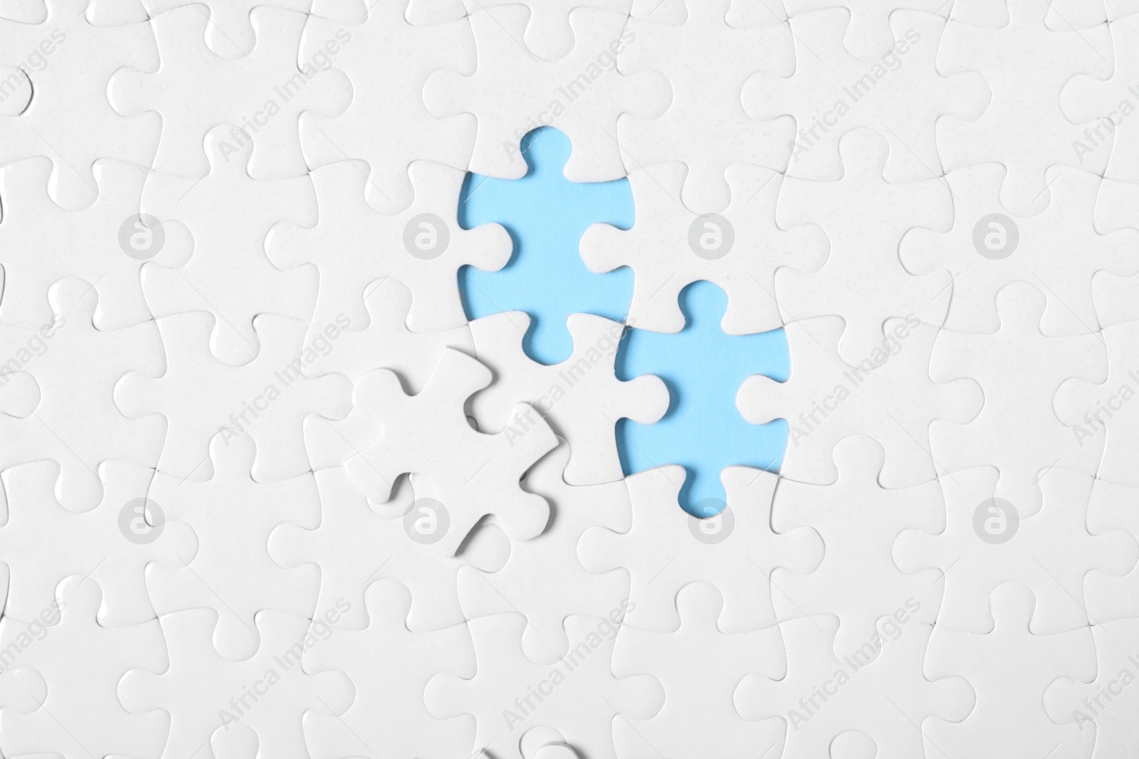 Photo of Blank white puzzle on light blue background, top view