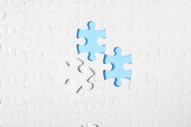 Photo of Blank white puzzle on light blue background, top view