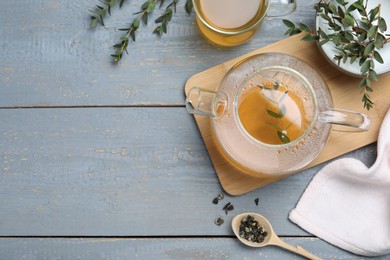 Aromatic eucalyptus tea on grey wooden table, flat lay. Space for text