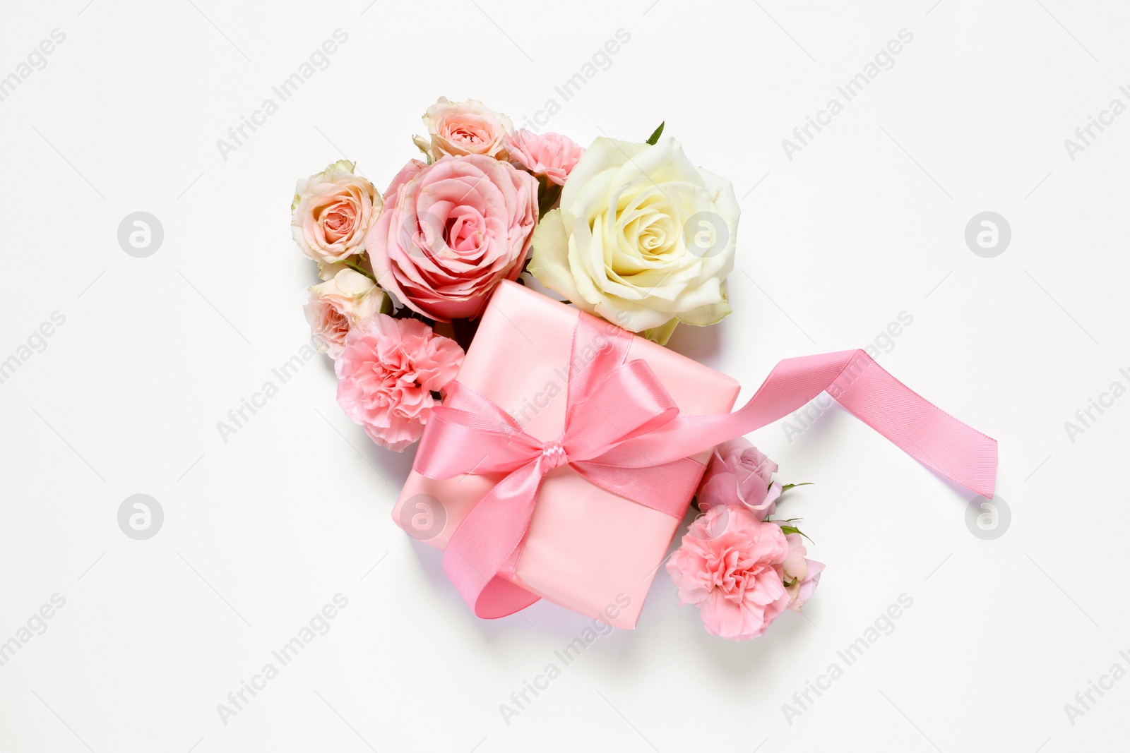 Photo of Gift box and beautiful flowers on white background, flat lay