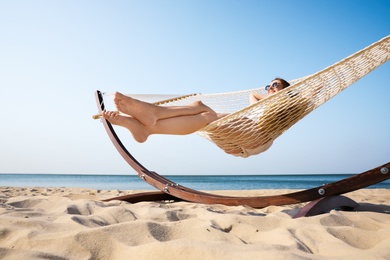 Photo of Young woman relaxing in hammock on beach