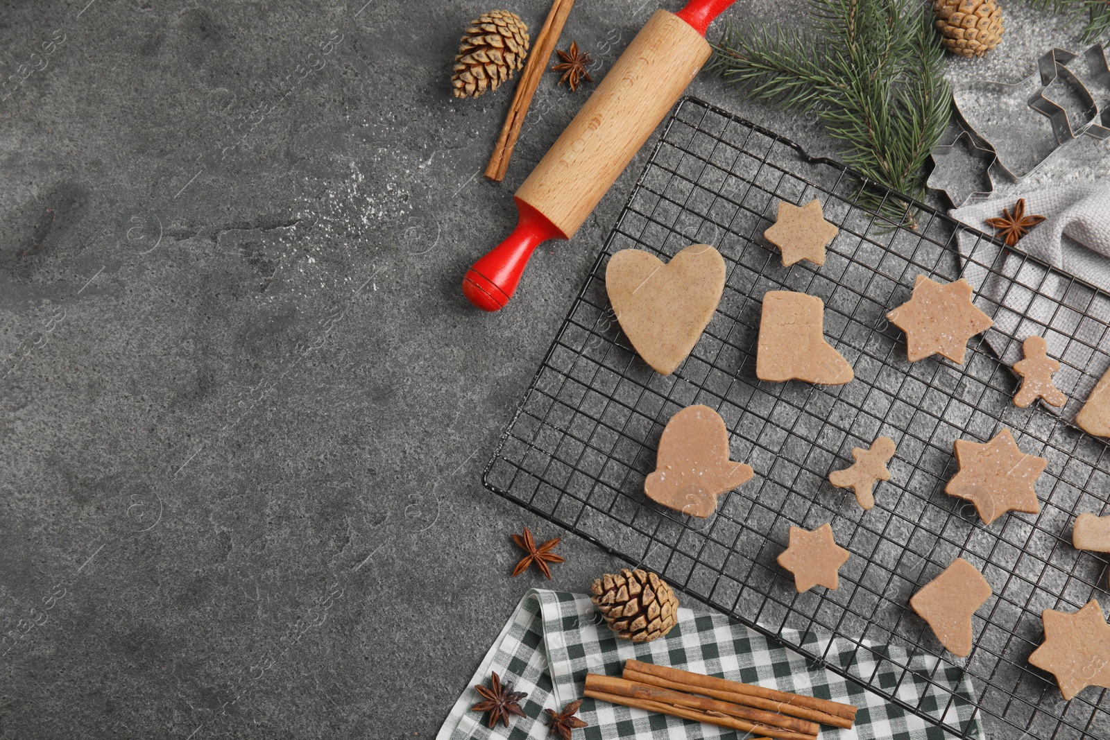 Photo of Homemade Christmas cookies. Flat lay composition with raw gingerbread biscuits on grey table, space for text