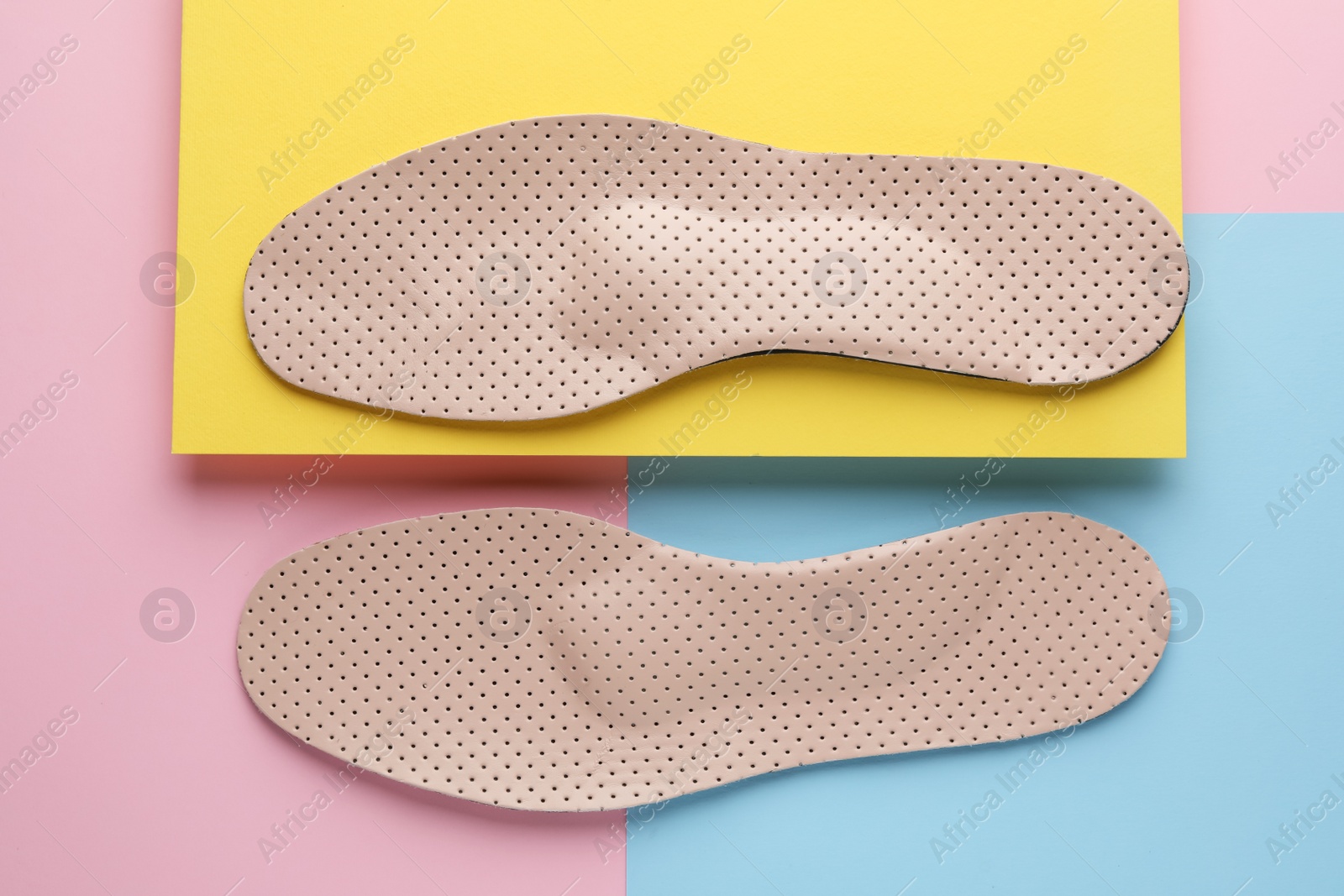 Photo of Beige orthopedic insoles on color background, flat lay