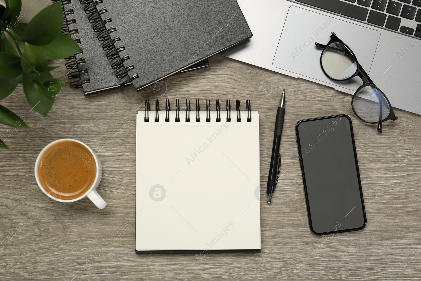 Photo of Flat lay composition with notebooks, laptop and smartphone on wooden table