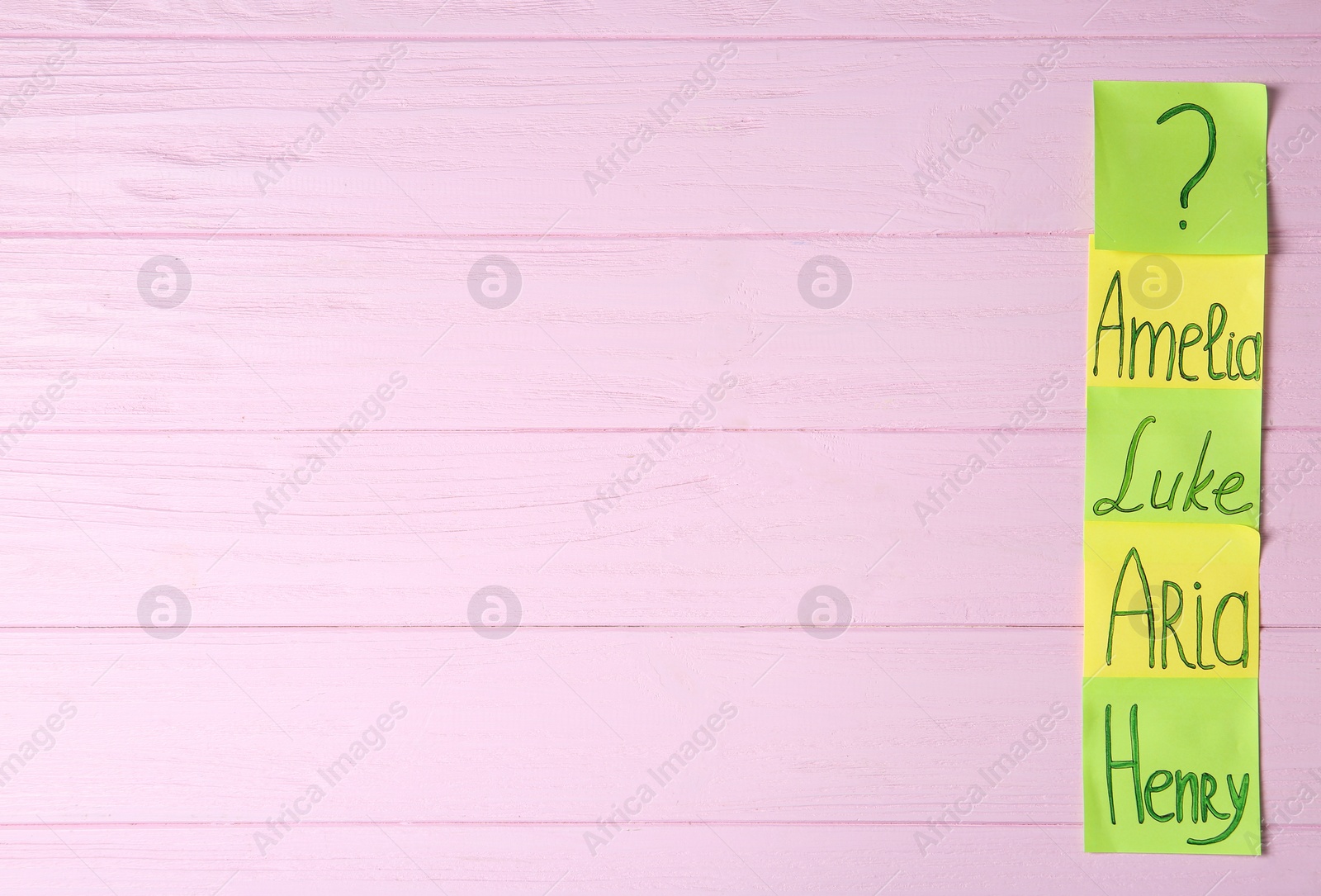 Photo of Sticky notes with written different baby names on pink wooden background, flat lay. Space for text