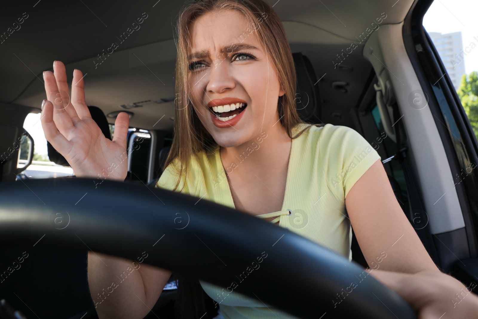 Photo of Emotional woman in car. Aggressive driving behavior