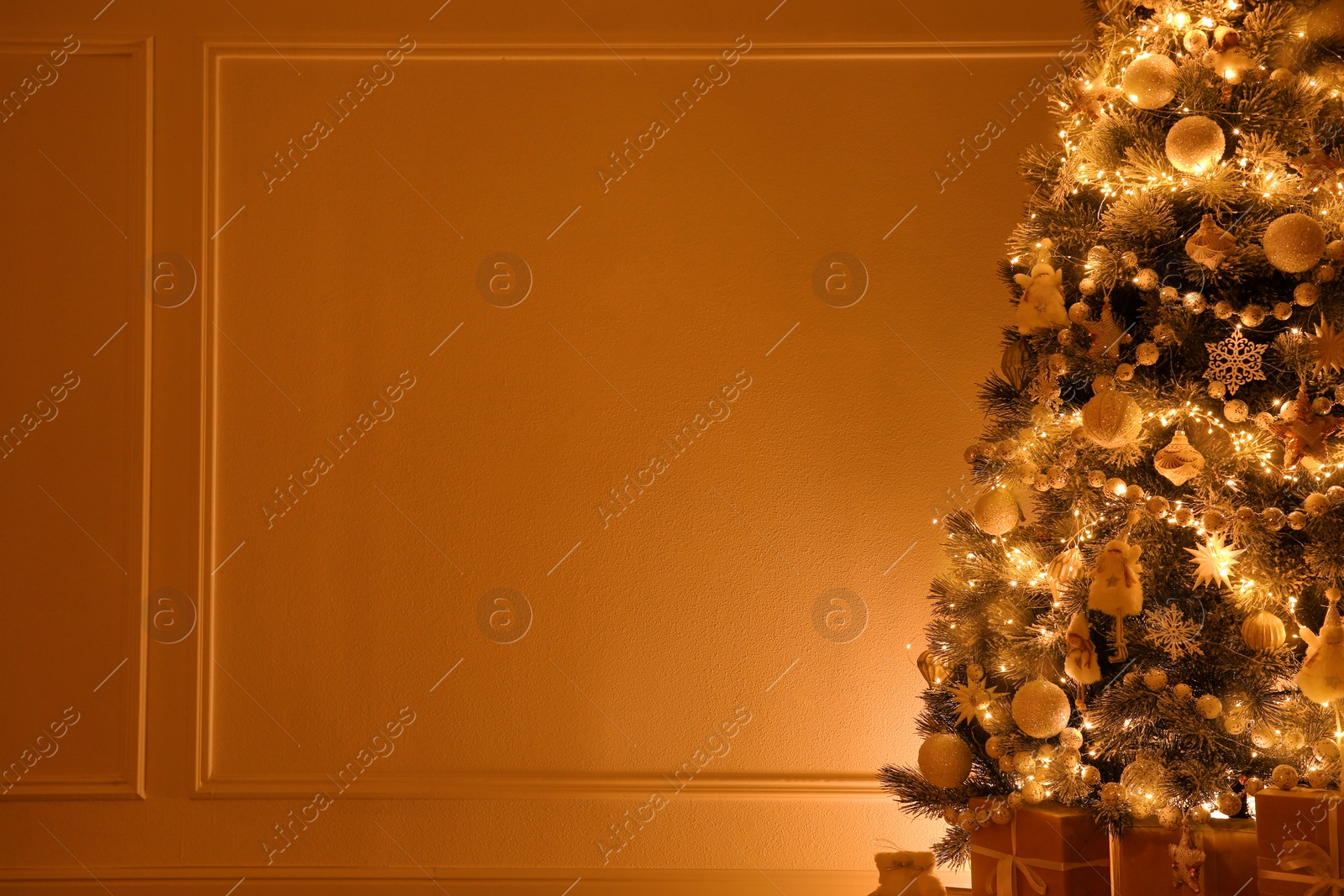 Photo of Beautiful decorated Christmas tree and gifts indoors. Space for text