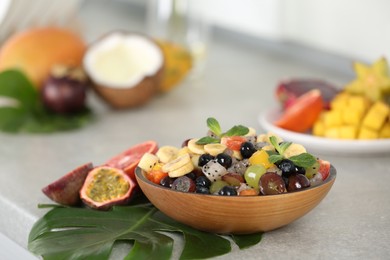 Photo of Delicious exotic fruit salad on light grey table