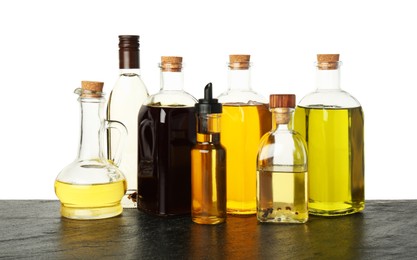 Photo of Vegetable fats. Different cooking oils on wooden table against white background