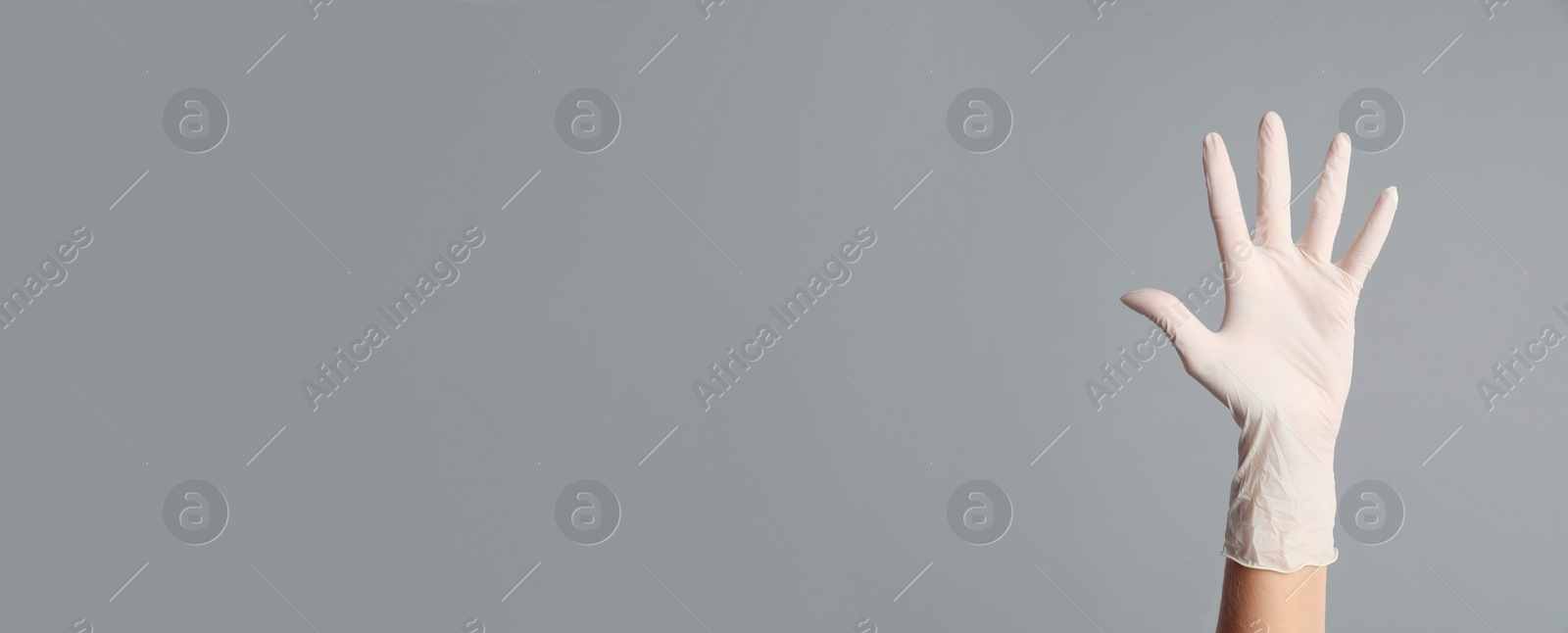 Image of Doctor wearing medical glove on grey background, closeup . Banner design with space for text 