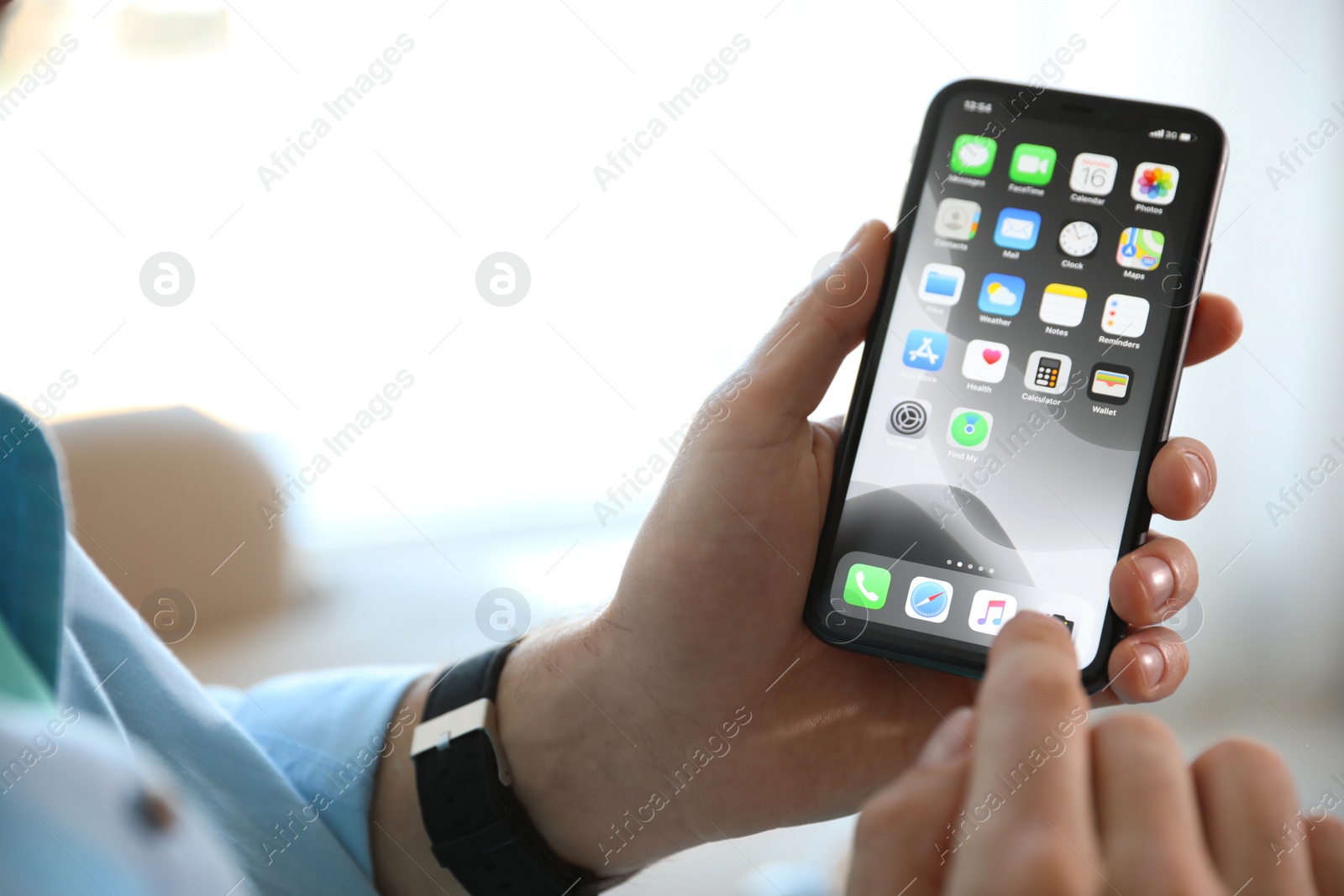 Photo of MYKOLAIV, UKRAINE - MARCH 16, 2020: Man holding iPhone 11 with home screen indoors, closeup