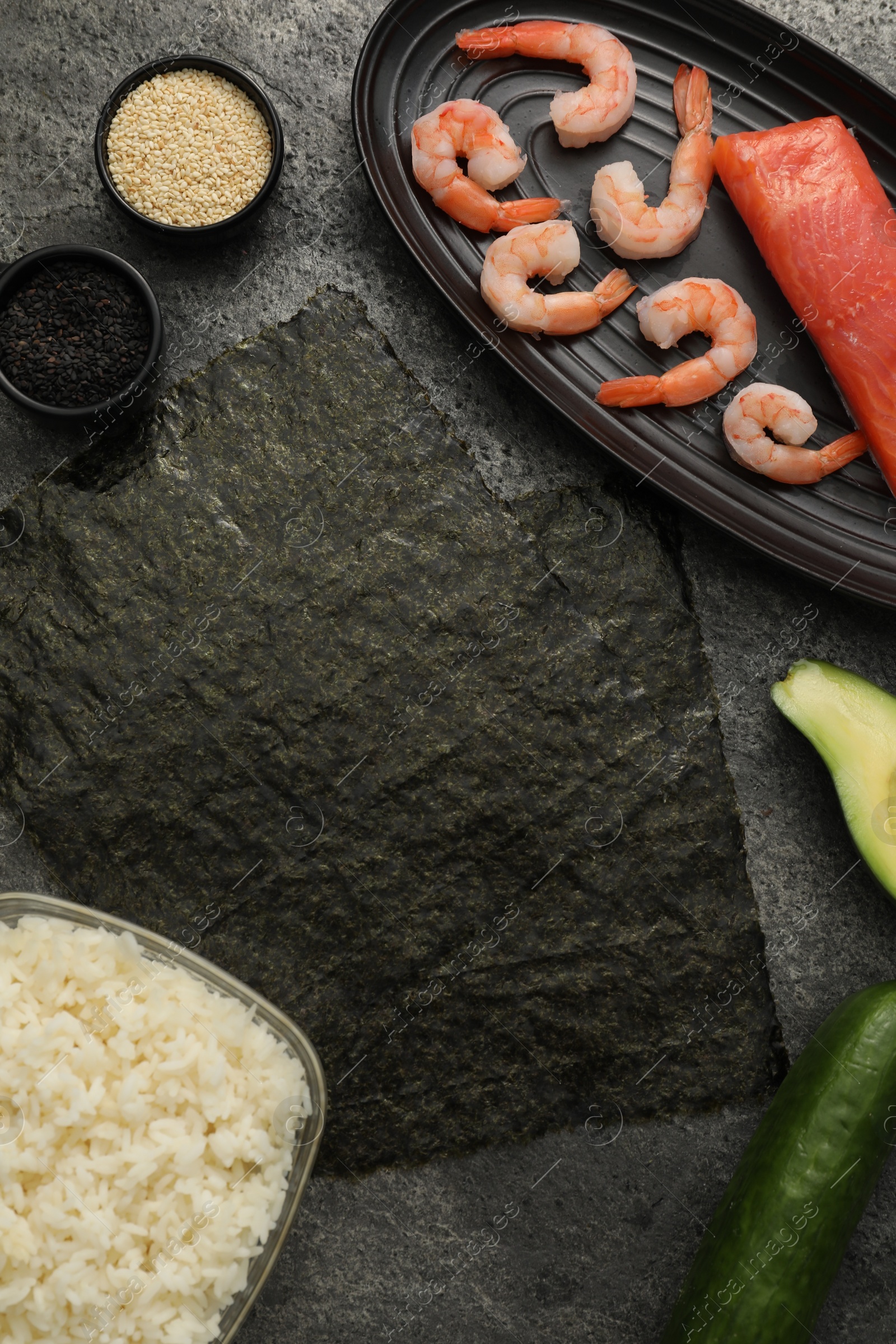 Photo of Flat lay composition with ingredients for sushi on dark textured table