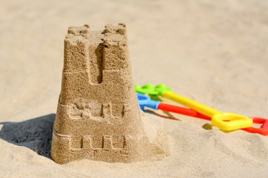 Photo of Sand castle and child plastic toys on beach. Space for text