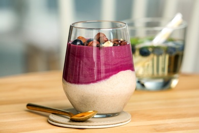 Glass with tasty acai smoothie on wooden table