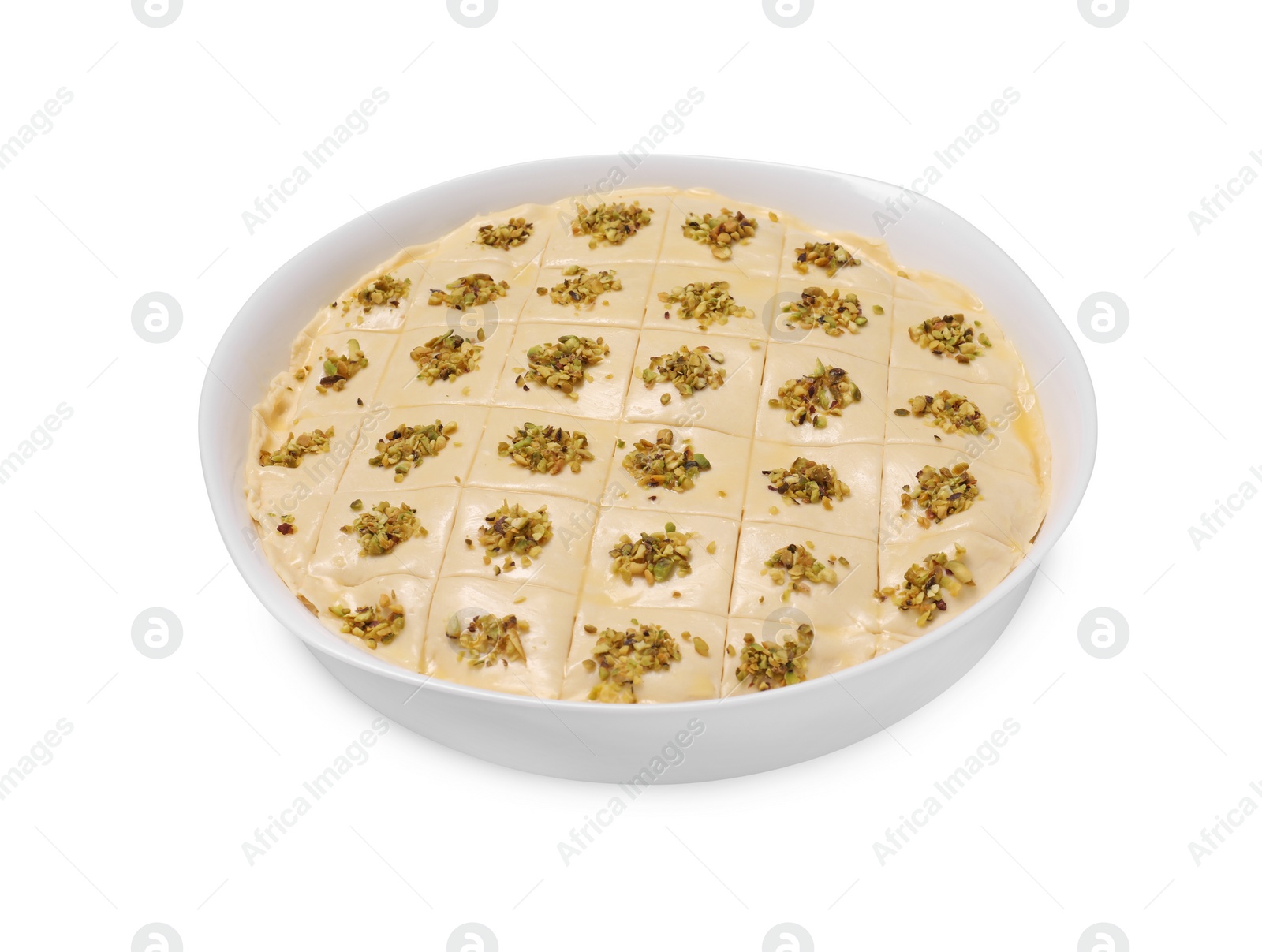 Photo of Making delicious baklava. Raw dough with pistachios in dish isolated on white