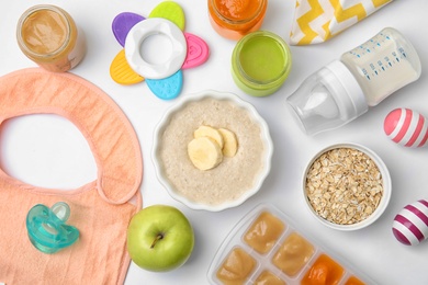 Photo of Flat lay composition with bowl of healthy baby food on white background