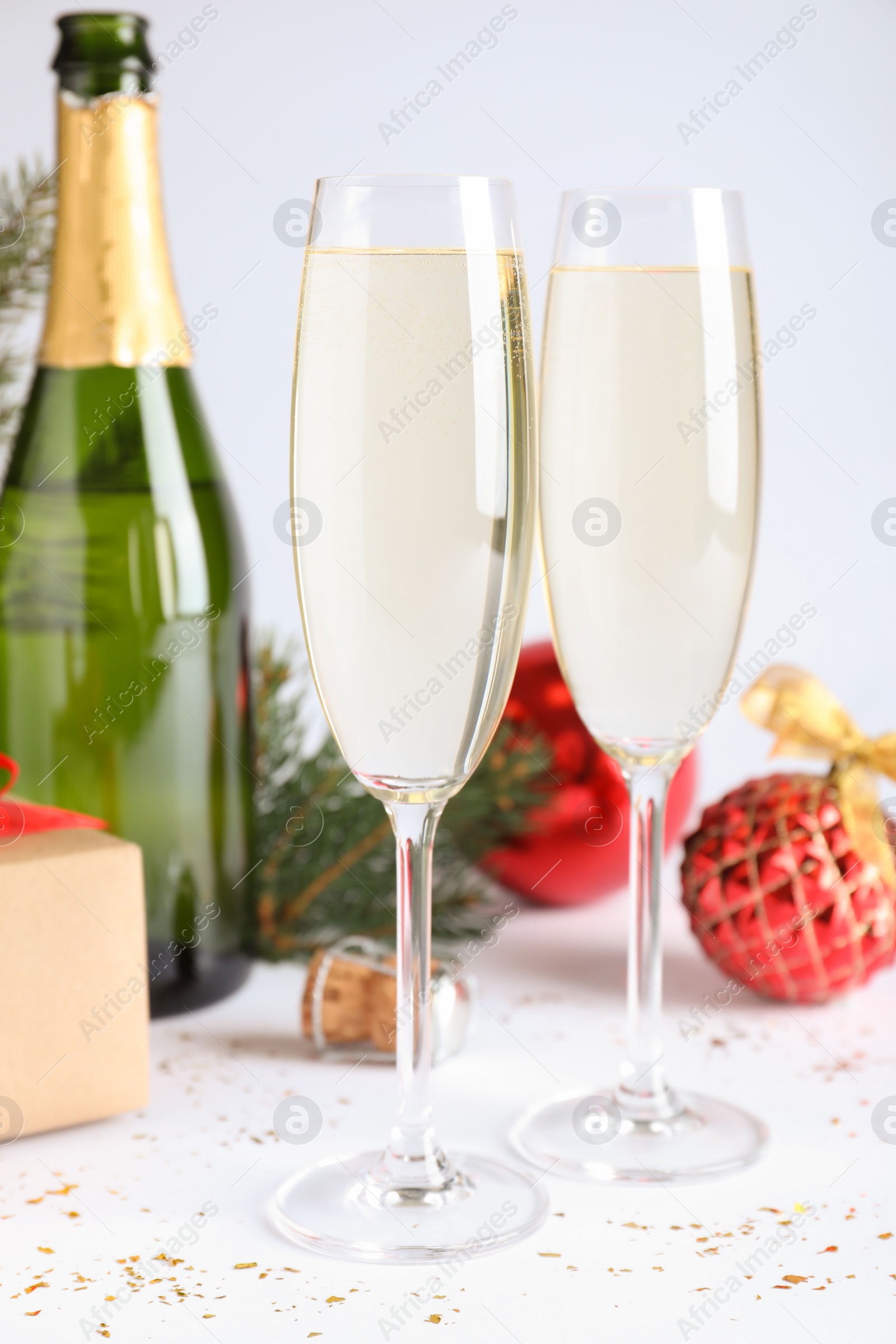 Photo of Happy New Year! Glasses of sparkling wine and festive decor on white background