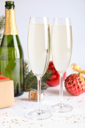 Photo of Happy New Year! Glasses of sparkling wine and festive decor on white background