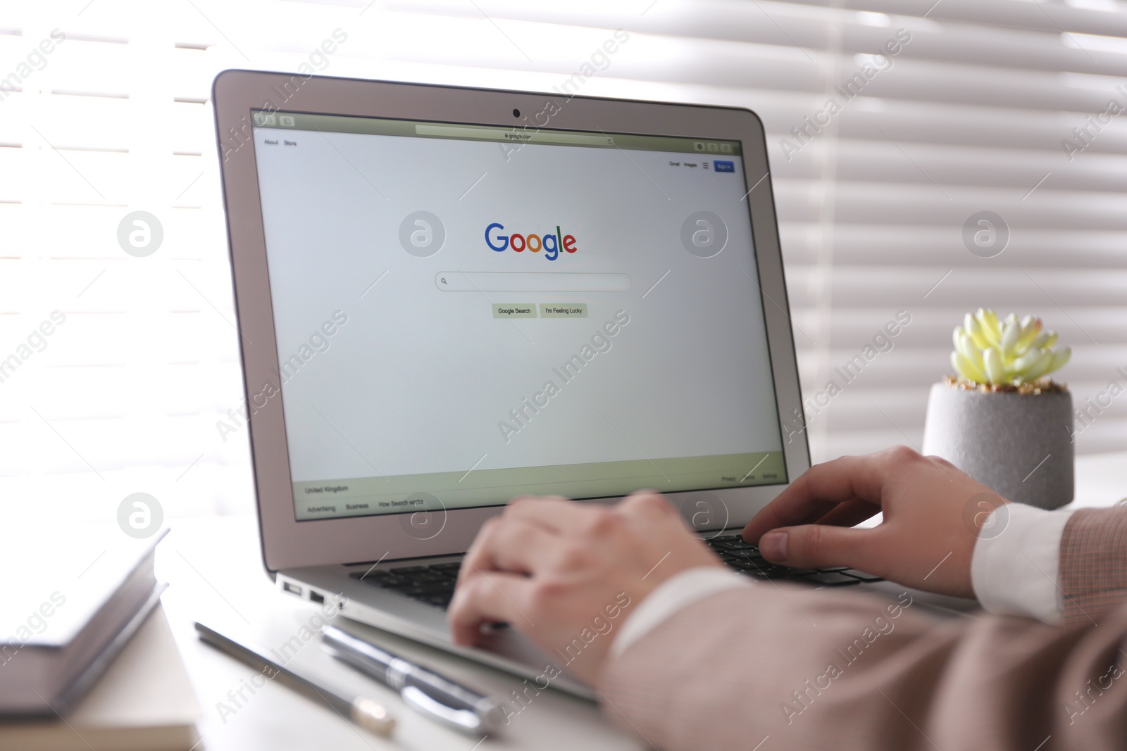 Photo of MYKOLAIV, UKRAINE - NOVEMBER 13, 2020: Woman using Google search on Apple Macbook Air in office, closeup