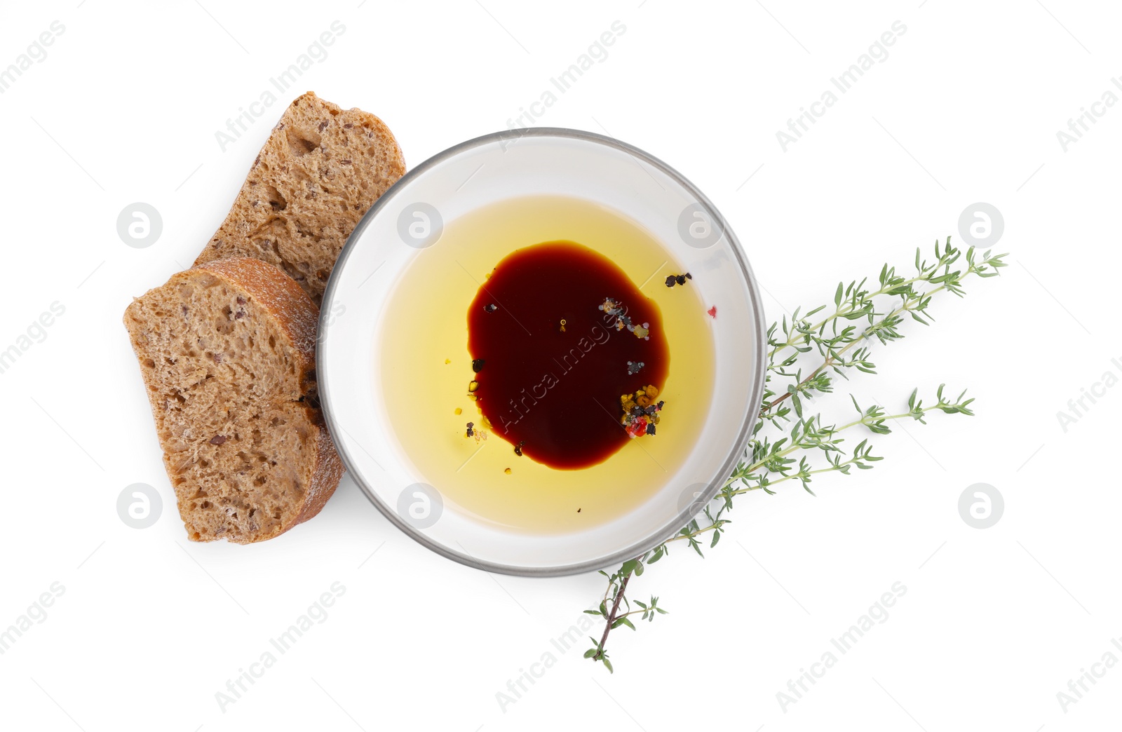 Photo of Bowl of organic balsamic vinegar with oil, spices and bread isolated on white, top view