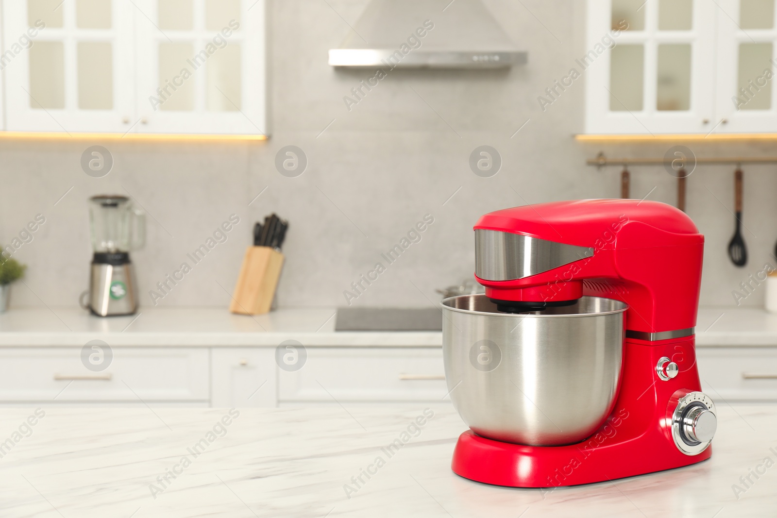 Photo of Modern red stand mixer on white marble table in kitchen, space for text