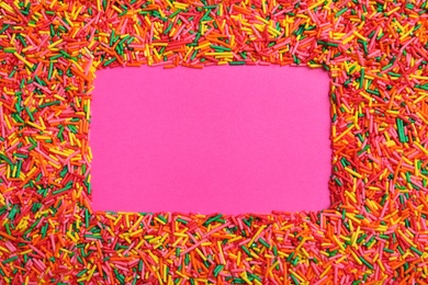 Frame of bright colorful sprinkles on pink background, flat lay with space for text. Confectionery decor