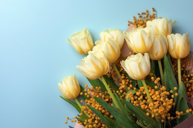 Bouquet with beautiful tulips and mimosa flowers on light grey background, top view. Space for text