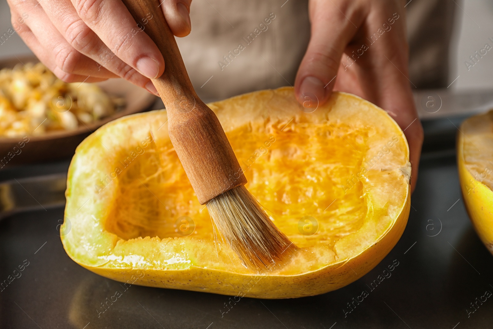 Photo of Woman preparing spaghetti squash on table, closeup