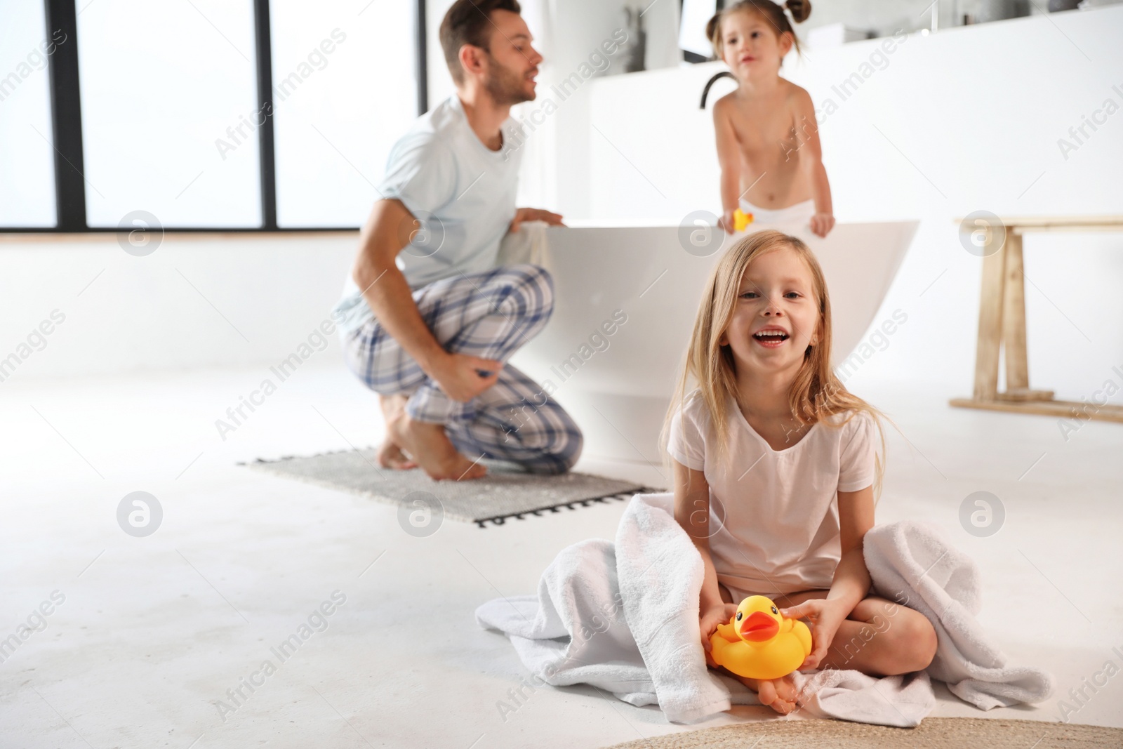 Photo of Cute little girl in bathroom. Space for text
