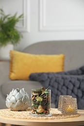 Photo of Glass jar with aromatic potpourri of dried flowers and different decor on wooden table indoors