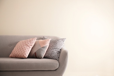 Photo of Different soft pillows on sofa in room