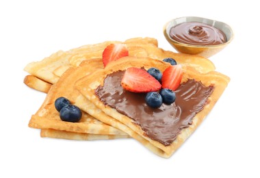 Photo of Tasty crepes with chocolate paste and berries isolated on white