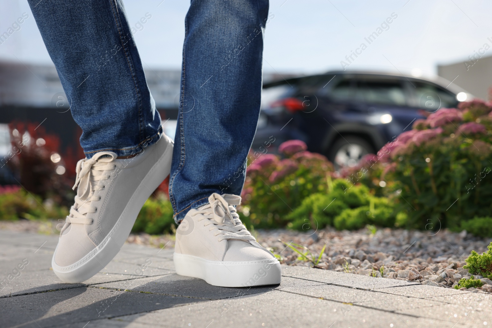 Photo of Man wearing pair of stylish sneakers outdoors, closeup