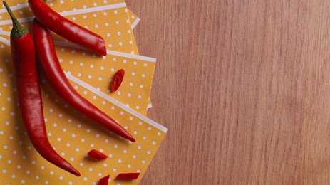 Photo of Pepper plasters and chili on wooden table, flat lay. Space for text