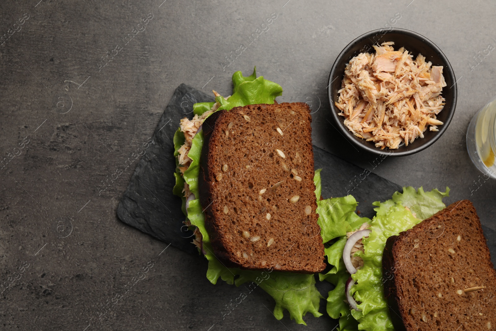 Photo of Delicious sandwiches with tuna and vegetables on light grey table, flat lay. Space for text