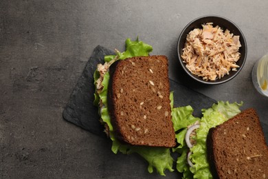 Delicious sandwiches with tuna and vegetables on light grey table, flat lay. Space for text
